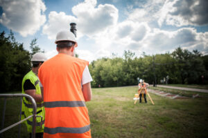 land surveyors collecting data in a field using surveying equipment