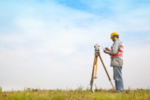 a land surveyor taking measurements in the field