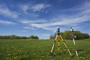 land survey equipment in grassy field