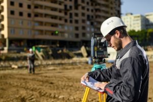 surveyor examines plans at construction site