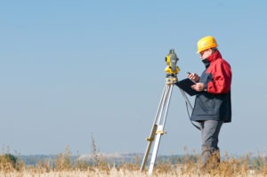 surveyor operates theodolite in field